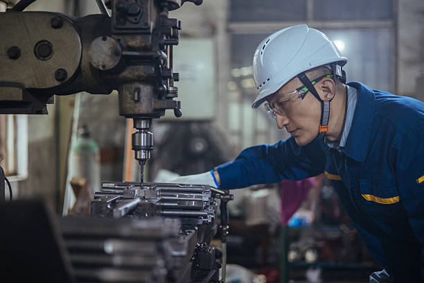 asian male engineer working on lathe